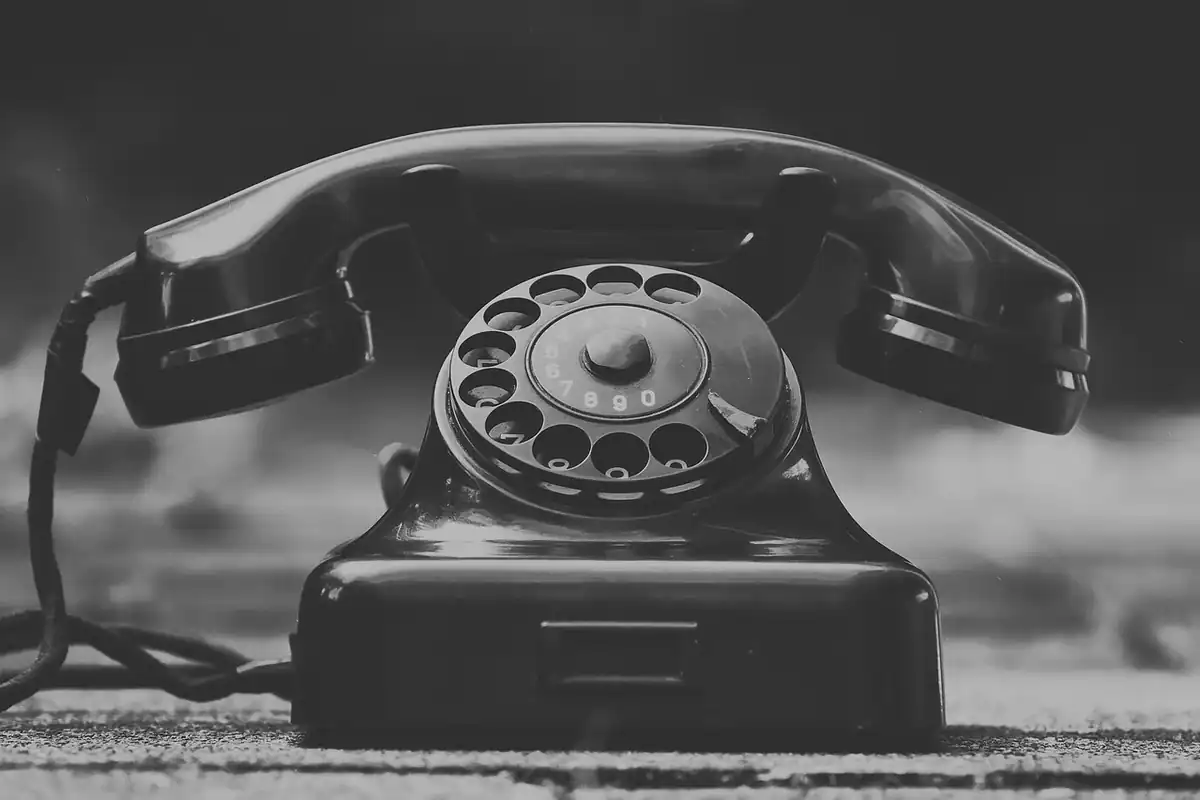 Telefon vechi cu disc, în alb-negru, simbol al apelurilor către cei dragi